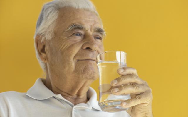 Oudere man met glas water